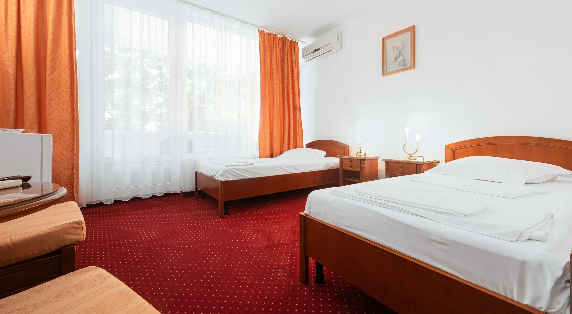Cameră luminoasă cu două paturi single și vedere spre grădină