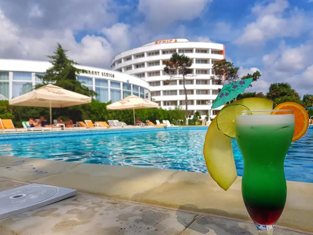 Cocktail la marginea piscinei, cu hotelul și Restaurant Scoica în fundal