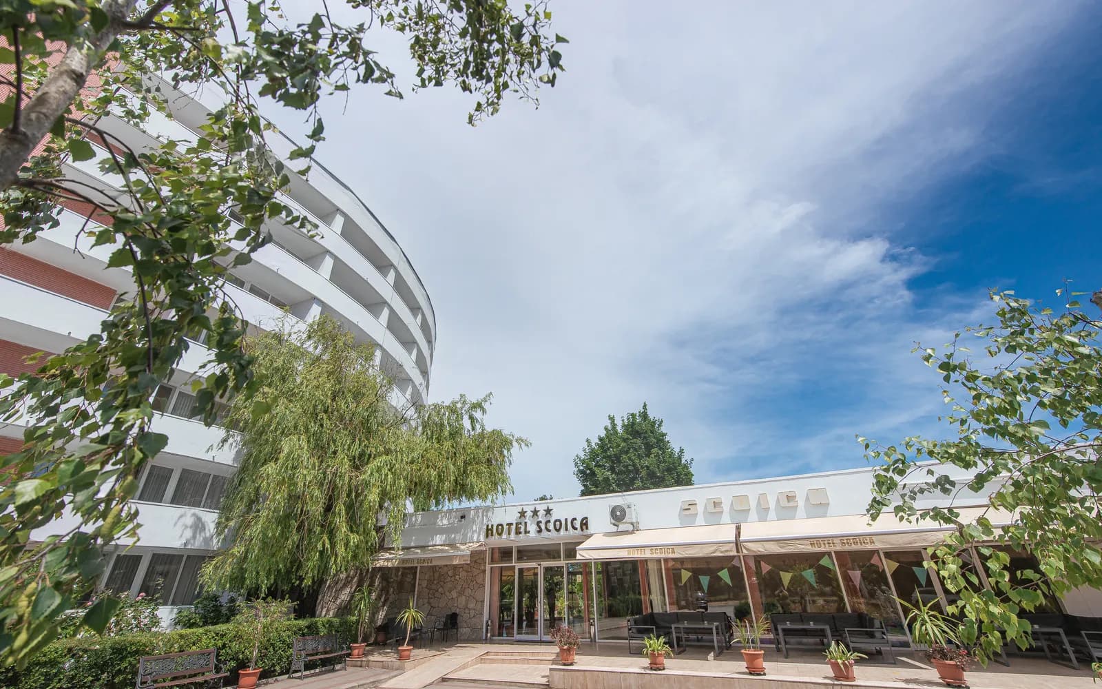 Hotel Scoica, ziua — fațada curbată și terasa, în lumina verii
