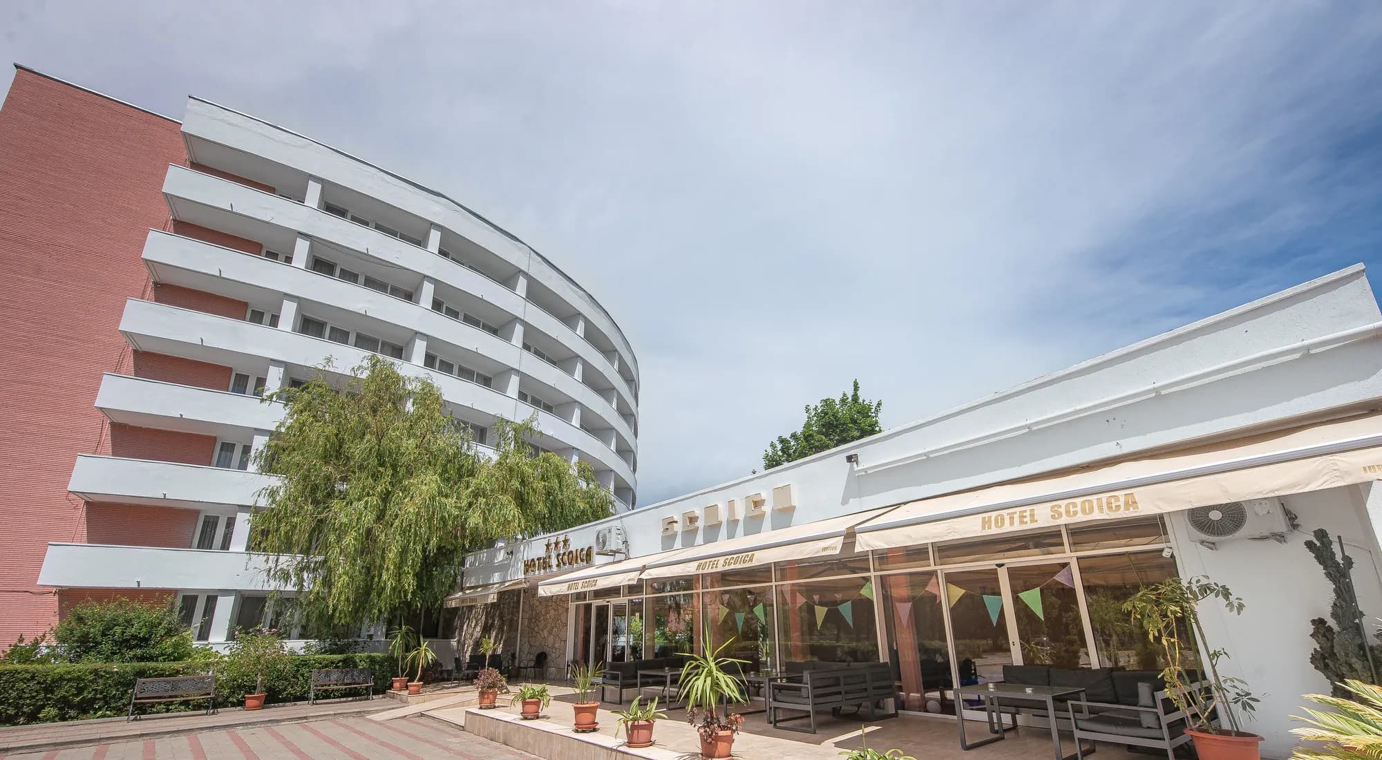 Fațada Hotelului Scoica cu terasa restaurantului în prim-plan